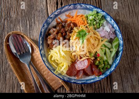 Reis gewürzt mit Garnelenpaste in Thai-Food-Stil Platte auf Holzplatte. Stockfoto