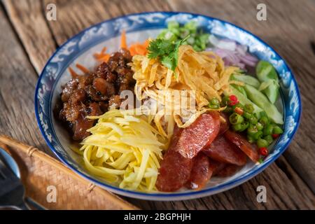 Reis gewürzt mit Garnelenpaste in Thai-Food-Stil Platte auf Holzplatte. Stockfoto