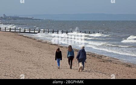 Portobello, Edinburgh, Schottland, Großbritannien. April 2020. Sehr ruhige Promenade und Strand, Temperatur 11 Grad mit Wind ENE 15mph, mögliche Böen von 23 mph, wie die NHS danke Flagge zeigt. Fußgänger mischten sich mit Radfahrern auf der Promenade oft zu eng für richtige körperliche soziale Distanz und wenige Menschen am Sandstrand. Quelle: Arch White/Alamy Live News. Stockfoto