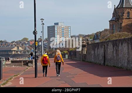 Portobello, Edinburgh, Schottland, Großbritannien. April 2020. Sehr ruhige Promenade und Strand, Temperatur 11 Grad mit Wind ENE 15mph, mögliche Böen von 23 mph, wie die NHS danke Flagge zeigt. Fußgänger mischten sich mit Radfahrern auf der Promenade oft zu eng für richtige körperliche soziale Distanz und wenige Menschen am Sandstrand. Quelle: Arch White/Alamy Live News. Stockfoto