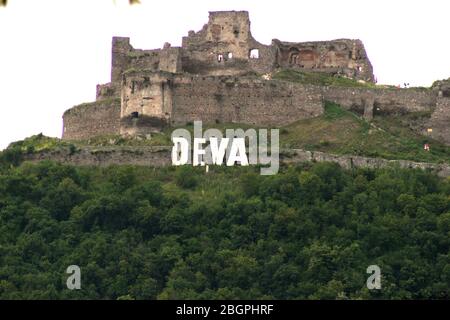 Deva, Rumänien. Die Festung von Deva aus dem 13. Jahrhundert und das Stadtschild auf dem Berg. Stockfoto