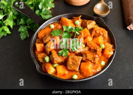 Rinderbraten mit Kartoffeln und Karotten in Tomatensoße in der Pfanne Stockfoto