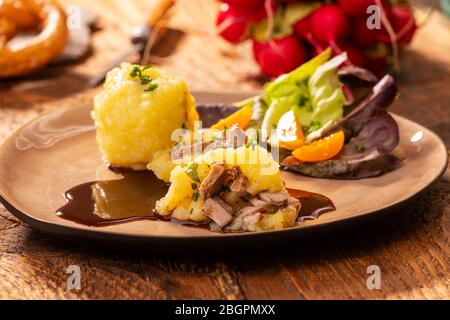 Gefüllte Kartoffelklöße mit Salat auf Holz Stockfoto