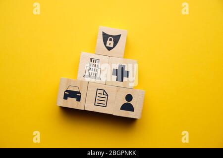 Auto, Gesundheit, Immobilien-Versicherung Konzept mit Symbolen auf Holzblöcken. Nahaufnahme. Stockfoto