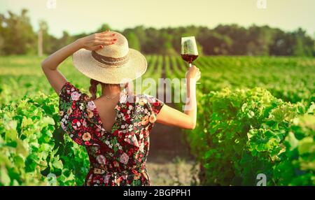 Asiatische Frau, die Rotwein im Weinberg während ihres Urlaubs trinkt, Vintage-Stil Stockfoto