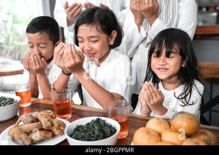 asiatische Kinder beten muslimischen offenen Arm vor dem Essen Abendessen Stockfoto