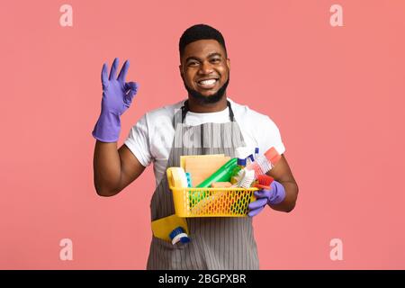 Lächelnder Afrikanischer Mann Holding Korb Mit Waschmitteln Und Zeigt Ok Zeichen Stockfoto