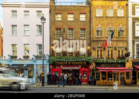 LONDON - FEBRUAR 2020: Typische West End-Straßenszene mit Bewegung verschwommenen Verkehr und Pubs und Restaurants in attraktiver georgianischer Architektur Stockfoto