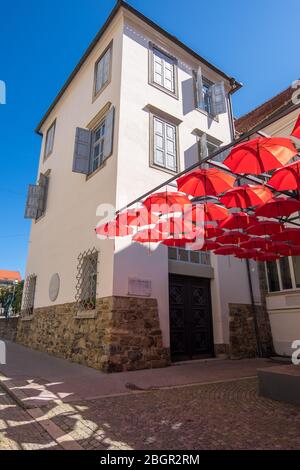 Maribor, Slowenien - 09. August 2019: Das rote Dach des Schirms vor dem Haupteingang des Regionalmuseums von Maribor Stockfoto