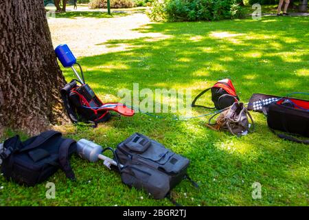 Equopment einer Nachrichtenbesatzung in einem Park, die während des Interviews auf Gras blieb Stockfoto