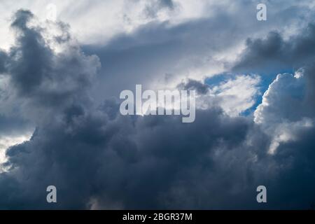 Cumulonimbus dunkel stürmisch geschwollene Wolken am Himmel und ein kleiner Fleck Blau am Himmel über Gloucestershire, Großbritannien Stockfoto