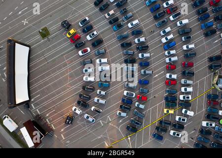 Chemnitz, Deutschland. April 2020. Besucher stehen mit ihren Autos im Drive-in-Kino in Chemnitz. Es ist das erste Mal seit Beginn der Kontaktbeschränkungen, dass es in der Stadt ein Kino gibt. Bis zu 230 Fahrzeuge können auf dem Platz vor dem 200 Quadratmeter Bildschirm oder der 50 Quadratmeter LED Wand parken. Bis zum 25. Juni gibt es jeden Tag um 17 Uhr einen Kinder- und Familienfilm und das Abendprogramm um 20 Uhr. Freitags und samstags gibt es ab 23:00 Uhr einen Mitternachtsfilm. (Luftaufnahme mit Drohne) Quelle: Jan Woitas/dpa-Zentralbild/dpa/Alamy Live News Stockfoto