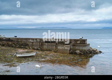 Ruderboot an einen Schafspollard gebunden und an der Küste in der Nähe von Corrie auf der Isle of Arran, Schottland, festgemacht Stockfoto