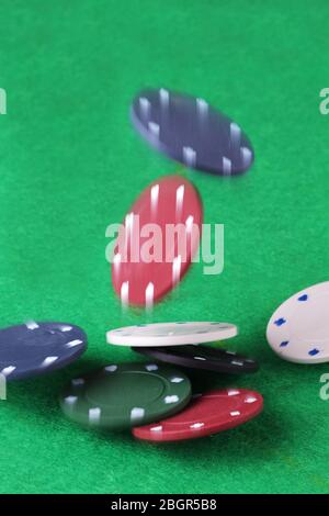 Den Topf spritzen. Casino Chips fallen auf einen Kartentisch. Stockfoto