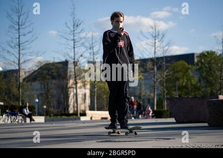 Ein Teenager, der vorsorglich eine Gesichtsmaske trug, während der Covid-19-Pandemie auf einer Straße Skateboarding.die polnische Regierung hat einige der Beschränkungen im Zusammenhang mit der Covid-19-Pandemie aufgeweicht. Bürger dürfen jetzt in Parks spazieren gehen, mehr Kunden dürfen Geschäfte betreten. Schutzmasken sind für jeden Bürger im öffentlichen Raum nach wie vor obligatorisch. Stockfoto