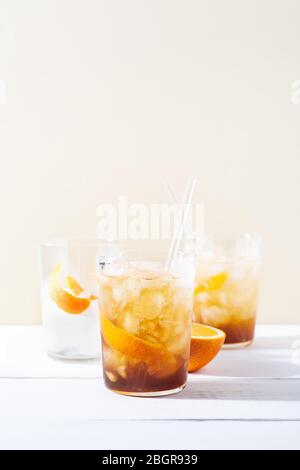 Kalt brauen Kaffee Mocktail mit Orangenschale und Glas Stroh.Glas mit Zitrus Espresso Tonic mit Eis auf weißem Hintergrund Stockfoto