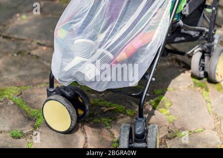 Kind im Kinderwagen mit schützenden Netz während Spaziergang abgedeckt. Kinderwagen mit Anti-mücken-Abdeckung. Midge-Schutz für Kinder während Outdoor Stockfoto