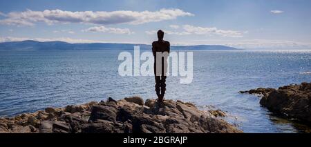 Antony Gormley Skulptur GRIFF einer abstrakten menschlichen Form Blick über Saddell Bay, Kilbrannan Sound zu Arran aus Felsen in Kintyre Peninsula, Scotl Stockfoto