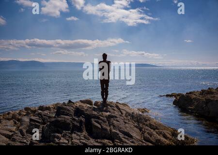 Antony Gormley Skulptur GRIFF einer abstrakten menschlichen Form Blick über Saddell Bay, Kilbrannan Sound zu Arran aus Felsen in Kintyre Peninsula, Scotl Stockfoto