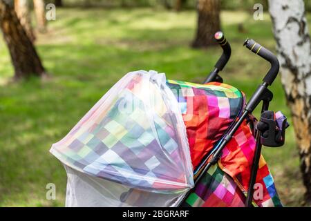 Kind im Kinderwagen mit schützenden Netz während Spaziergang abgedeckt. Kinderwagen mit Anti-mücken-Abdeckung. Midge-Schutz für Kinder während Outdoor Stockfoto