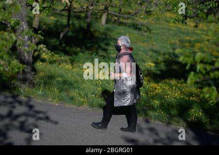 Prag, Tschechische Republik. April 2020. Eine Frau mit Gesichtsmaske geht im Petrin Park in Prag, Tschechien, 22. April 2020. Quelle: Ondrej Deml/CTK Photo/Alamy Live News Stockfoto