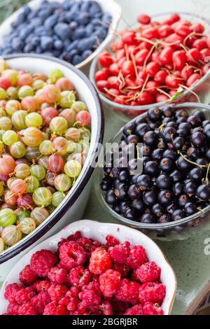Sommer Beeren Hintergrund, Stachelbeeren, schwarze Johannisbeere, Berberitze in Schüssel, gesunde Bio-hausgemachten Vitaminen essen Stockfoto