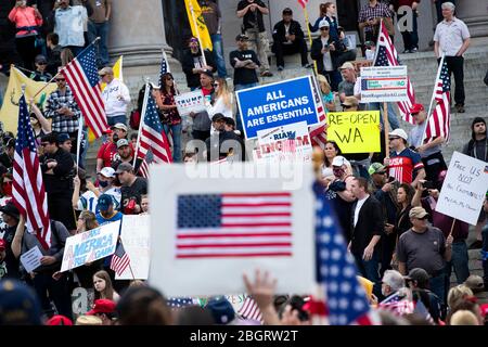Die Menschen halten Zeichen, die Präsident Donald Trump unterstützen und fordern, dass der Staat Washington bei einem Protest gegen die Beschränkungen des Aufenthalts im eigenen Haus wieder eröffnet wird Stockfoto