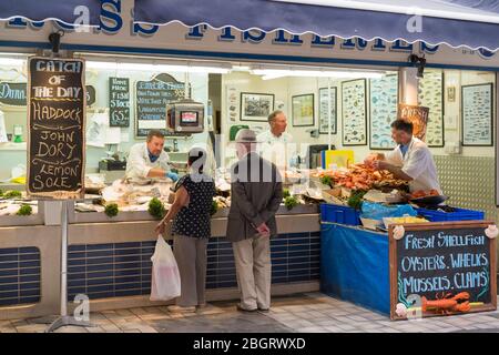 Kunden, die im beliebten Fischstand Dunn-Ross Fisheries am Beresford Street Market, St Helier, Jersey, Channel Isles einkaufen Stockfoto