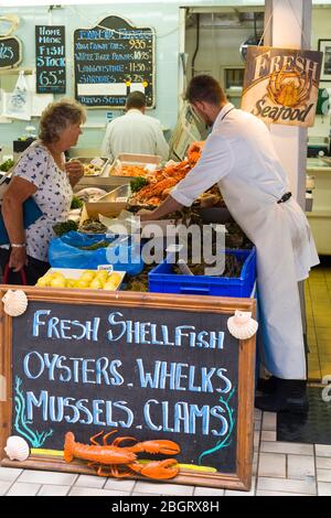 Kunden kaufen im beliebten Fischstand Dunn-Ross Fisheries am Beresford Street Market, St Helier, Jersey, Channel Isles ein Stockfoto