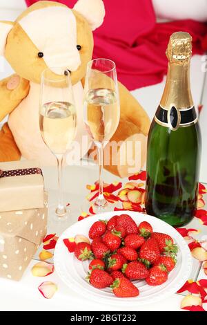 Romantisches Stillleben mit Champagner, Erdbeeren und Rosenblättern aus nächster Nähe Stockfoto