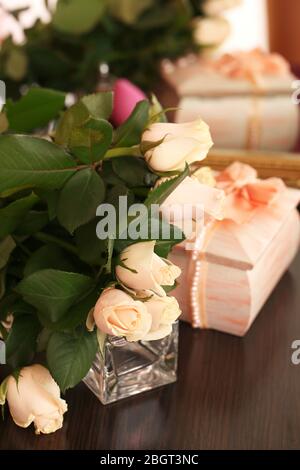 Schöne Rosen, Parfüms auf dem Tisch in der Nähe des Spiegels Stockfoto