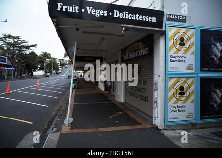 Bleib zu Hause, rette Leben Poster auf einer Plakatwand und geschlossenen Läden und leeren, menschenleeren Straßen während der Sperrung des Coronavirus Covid-19 in Auckland. Stockfoto