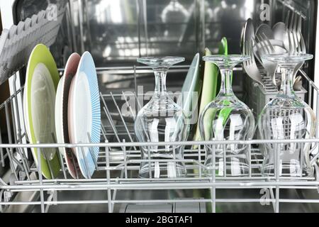 Offener Geschirrspüler mit sauberen Utensilien Stockfoto