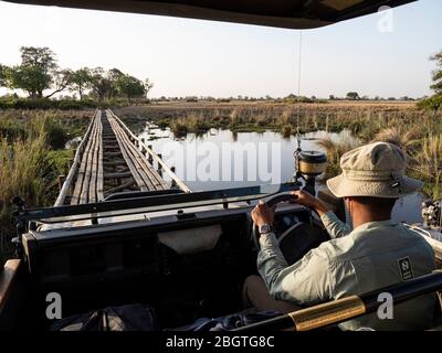 Wildfahrzeug über Holzbrücke im Okavango Delta, Botswana, Südafrika. Stockfoto