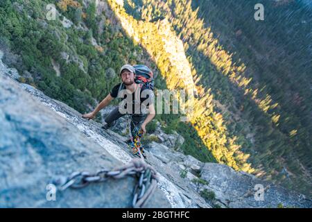 Mann, der oben schaut, das lustige Gesicht tut, während er Seil herauf El Capitan rüllt Stockfoto