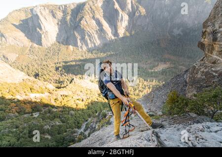 Mann, der Seil auf El Capitan tuend lustige Gesicht mit Rucksack Stockfoto