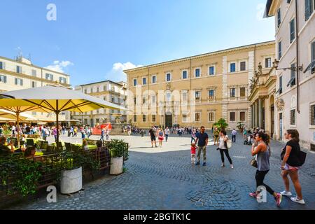Lebendiger Sommertag auf der Piazza Santa Maria in Trastevere in Rom Italien, während Touristen und Einheimische die Cafés und Brunnen vor der Kathedrale genießen. Stockfoto