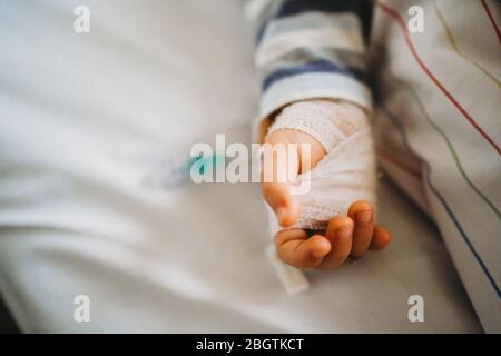 Baby Kind Hand mit IV krank im Krankenhaus mit einem Virus Coronavirus Stockfoto