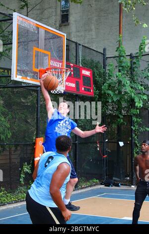 Amateur-Spieler, die um den Ball unter dem Brett beim Basketball spielen in "The Cage", West 4th Street Courts, Manhattan am 29. JULI 2019 i Stockfoto