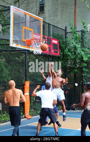Amateur-Spieler, die um den Ball unter dem Brett beim Basketball spielen in "The Cage", West 4th Street Courts, Manhattan am 29. JULI 2019 i Stockfoto