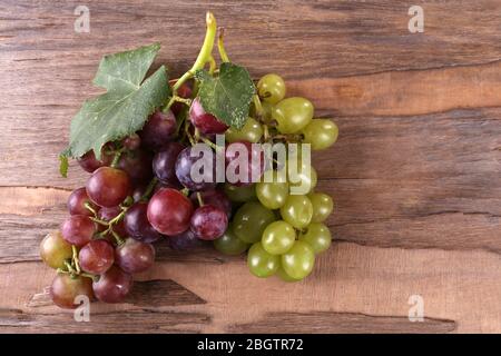 Trauben verschiedener Arten von Trauben auf Holzhintergrund Stockfoto