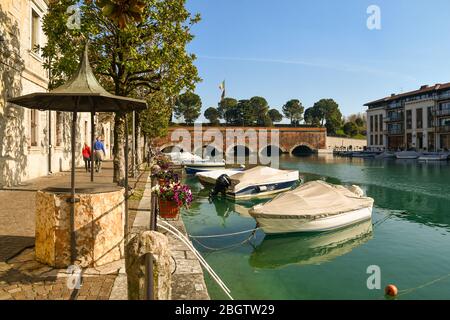 Blick auf den Kanal Canale di Mezzo in der Altstadt (UNESCO-Weltkulturerbe) mit der Brücke Ponte dei Voltoni (16. jh.), Peschiera del Garda, Verona, Italien Stockfoto