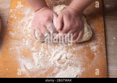 Weibliche Hände mischen Teig in der Küche. Stockfoto