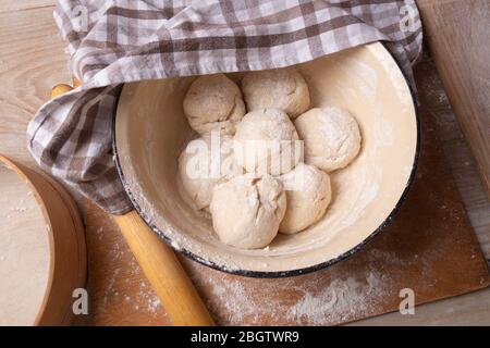 Teigkugeln sind in einer großen gelben Schüssel. Kochen zu Hause. Stockfoto