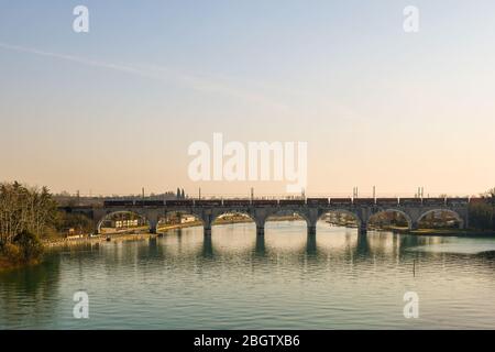 Panoramasicht auf die Bogenbahnbrücke am Fluss Mincio in Peschiera del Garda, einer alten Stadt am Ufer des Gardasees, Verona, Venetien, Italien Stockfoto