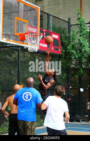 Amateur-Spieler, die um den Ball unter dem Brett beim Basketball spielen in "The Cage", West 4th Street Courts, Manhattan am 29. JULI 2019 i Stockfoto