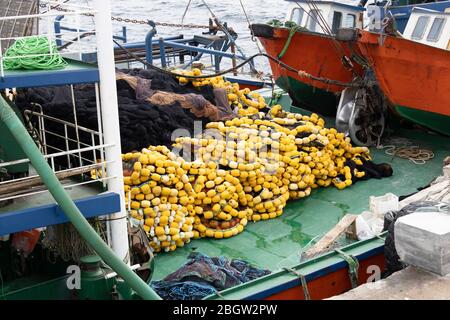 Fischernetze auf dem Boot. Es sind gelbe Kugeln darauf. Stockfoto