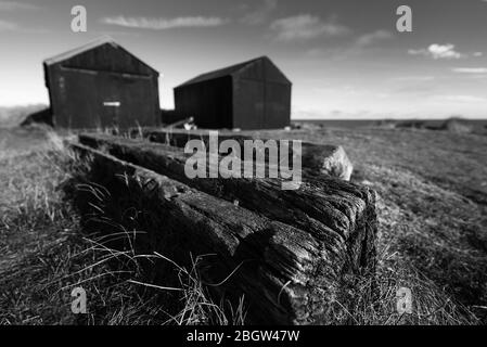 Fischerhütten mit altem Holz im Vordergrund ii. Mono- Winterton, November 2016 Stockfoto