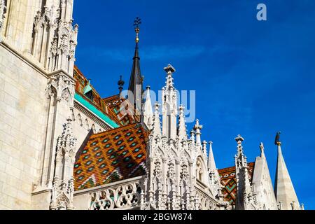 Dachdetails mit dekorativen floralen Fliesen auf der Mathias-Kirche, einer der wichtigsten Sehenswürdigkeiten der Fischerbastei im Buda-Teil von Budapest, Ungarn. Stockfoto