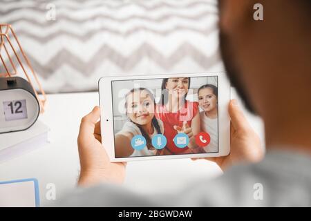 Junger Mann Video-Chat mit seiner Familie zu Hause Stockfoto